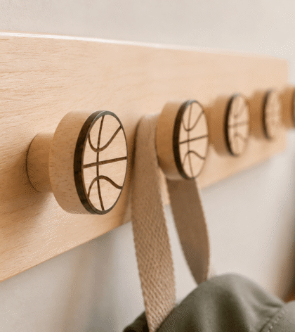 crochet mural en bois massif clair avec supports en forme de ballon de basketball